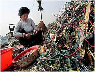 woman sorting electronics in landfill